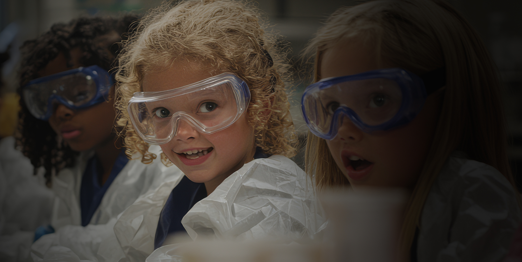 Students in a science classroom wearing safety goggles